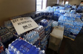 Hundreds of cases of bottled water are stored at Our Lady of Guadalupe Church, Friday, Feb. 5, 2016 in Flint, Mich. Michigan Gov. Rick Snyder is defending how his office responded to an email flagging a potential link between a surge in Legionnaires' disease and Flint's water. (AP Photo/Carlos Osorio)