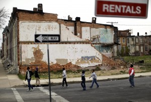 In this April 4, 2013 picture, a group of boys walk past a partially collapsed row house in Baltimore. (AP Photo/Patrick Semansky)