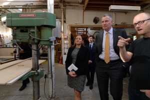 New York City Mayor Bill de Blasio and City Council Speaker Melissa Mark-Viverito listen to Sam Morse, owner of Southside Design and Building, as they tour his shop at the Greenpoint Manufacturing & Design Center in the Greenpoint section of the borough of Brooklyn in New York, on Tuesday, Nov. 2, 2015. (Todd Maisel/The Daily News via AP)