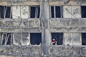 Firemen examine inside the Grenfell Tower in London as firefighters continue to damp-down the deadly fire, Thursday, June 15, 2017. (AP Photo/Frank Augstein)