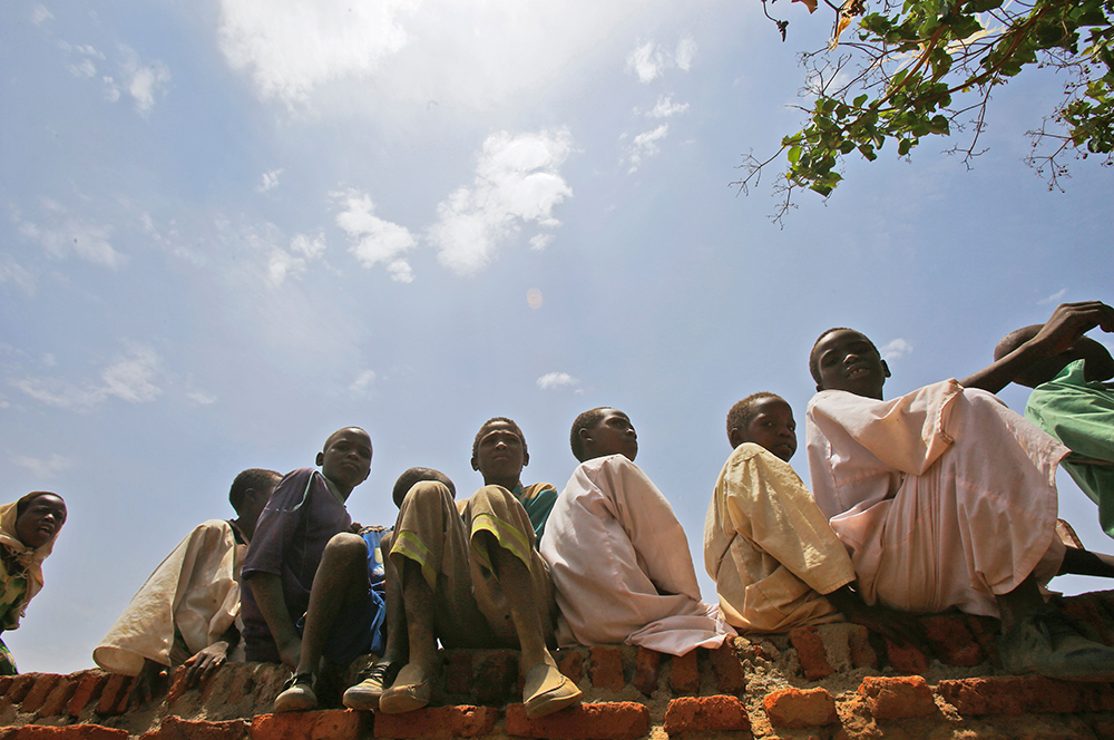 Sudanese children sitting on a wall