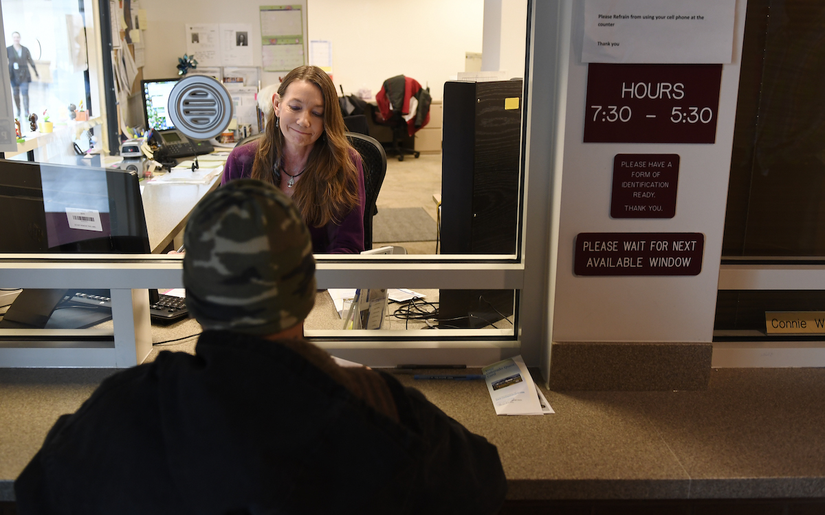 An applicant for food stamps talks with a county official.