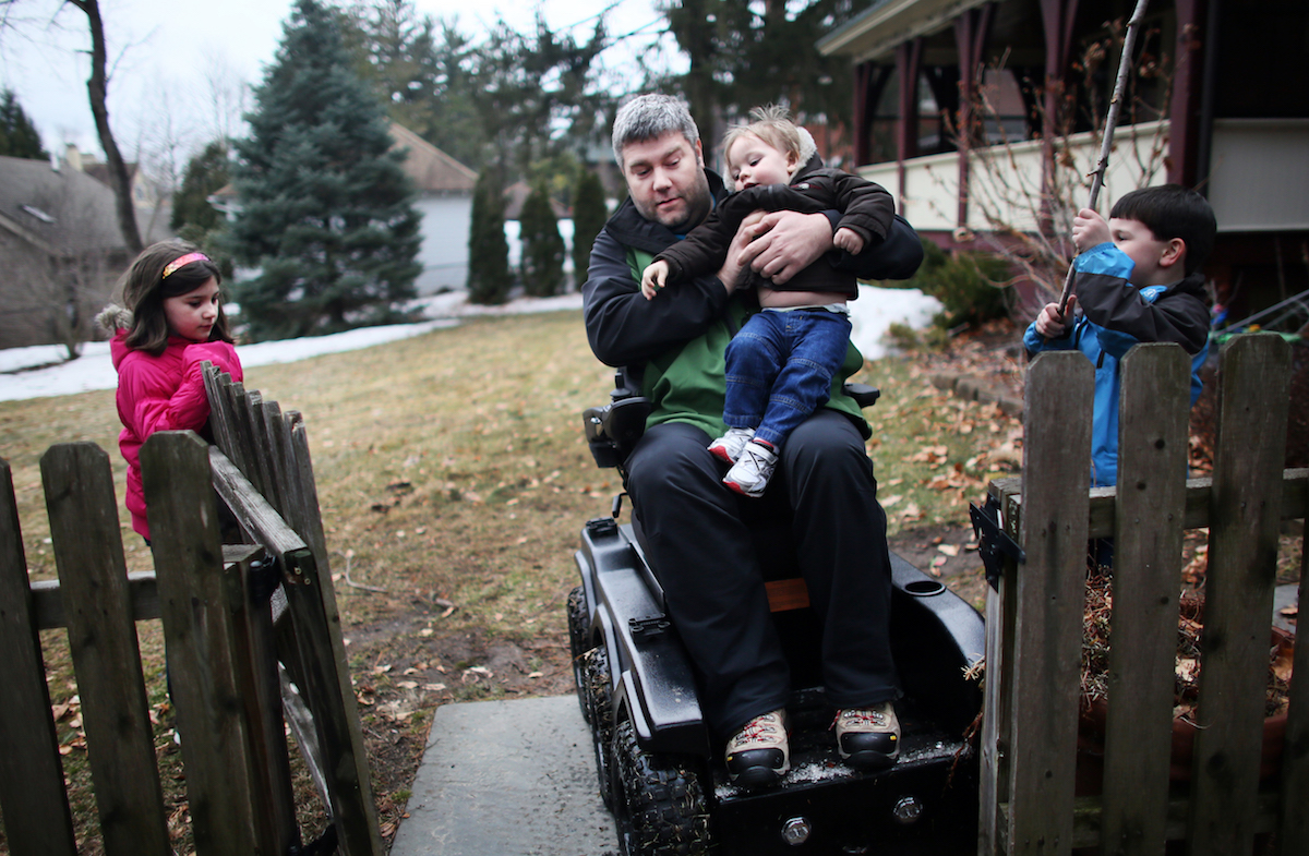 wheelchair user carrying young child