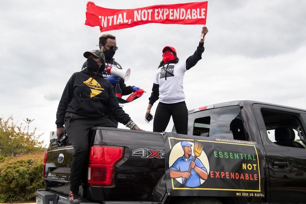 activists holding an essential not expendable sign