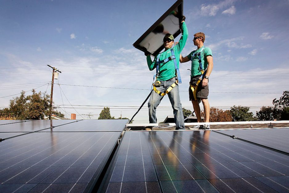 two workers installing solar panels